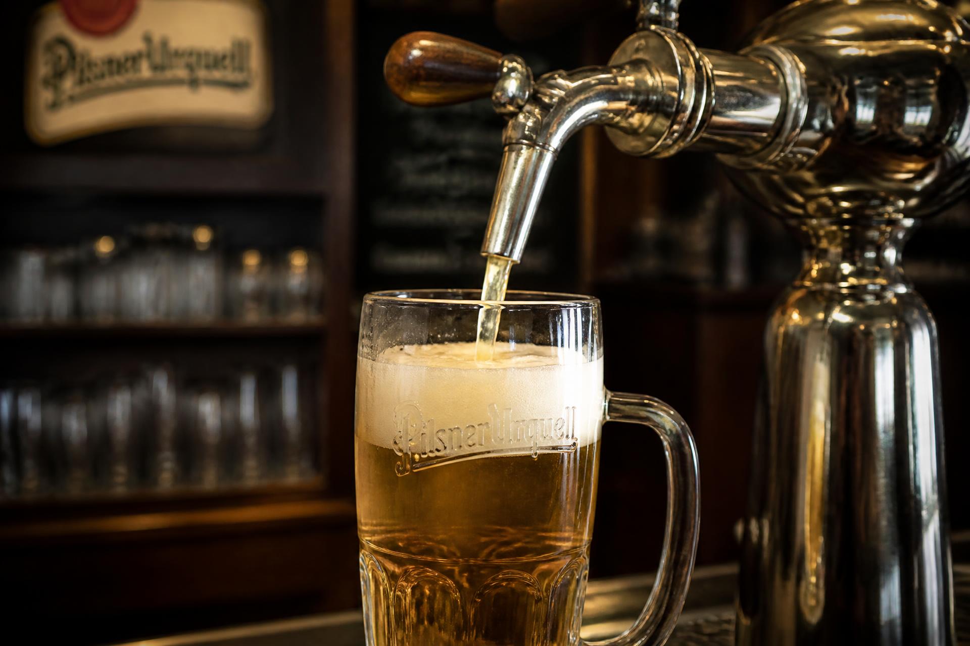 Mosazná pípa s čerstvě načepovaným Pilsner Urquell v Karlínské pivnici